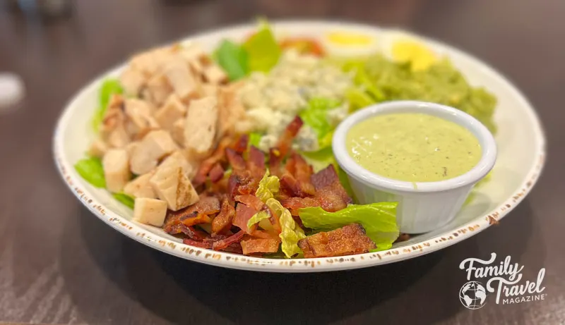 Cobb salad with bacon and chicken, and dressing on the side