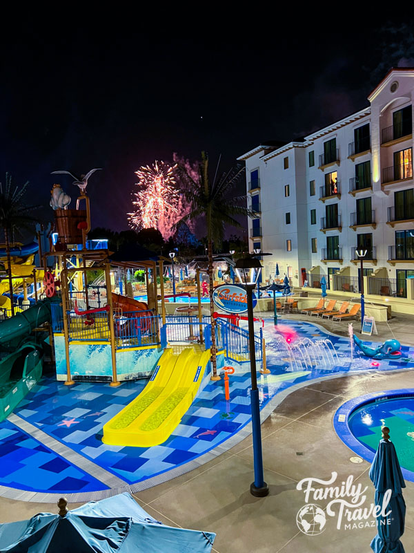Waterpark with waterslides and fireworks above it. 
