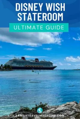 The Disney Wish docked at Castaway Cay with rocks in the foreground.