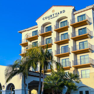 Exterior of the Courtyard hotel with palm trees in front