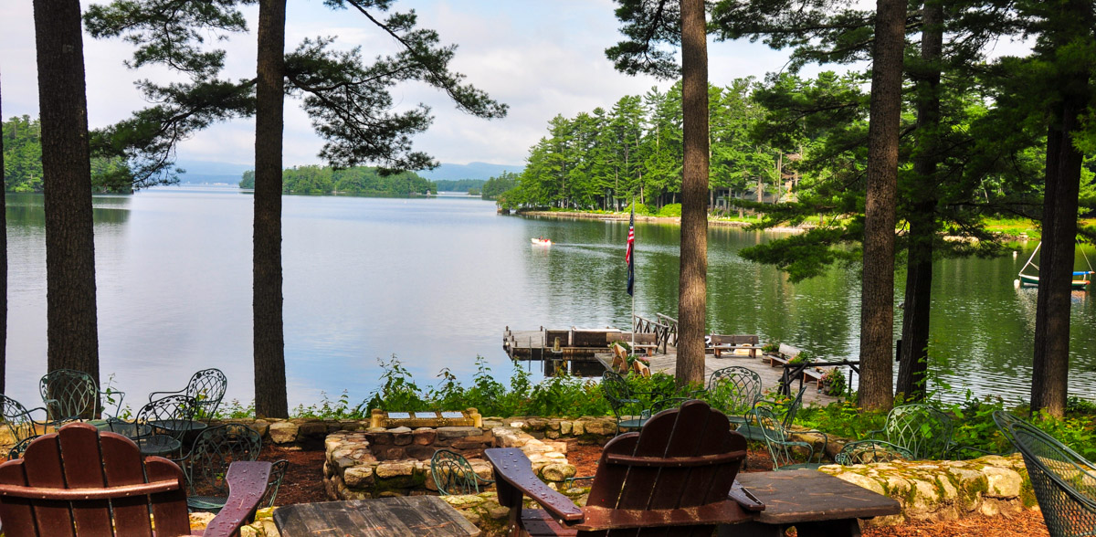 view of lake with pier, and chairs overlooking the water at Migis Lodge