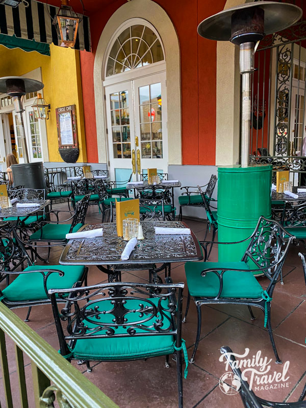 Patio at Ralph Brennan's with iron chairs and table and green, orange, and yellow accents