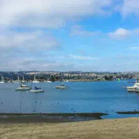 Small San Diego beach with boats docked and in the water.
