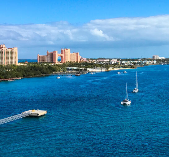 Atlantis buildings from afar with water and boats in foreground.