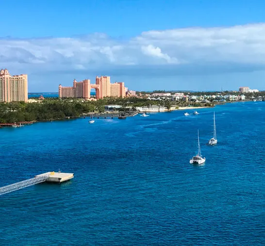 Atlantis buildings from afar with water and boats in foreground.