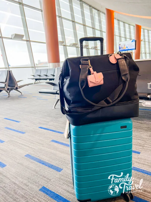 Beis Mini Weekender bag on top of Away bigger carry-on bag at the airport