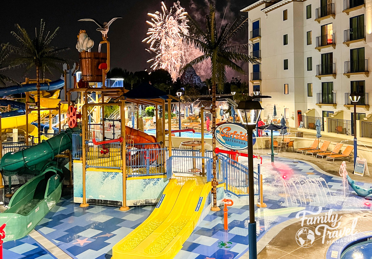 Waterpark at night with fireworks over water slides and bucket at the Courtyard Anaheim - one of the best hotels walking distance to Disneyland 