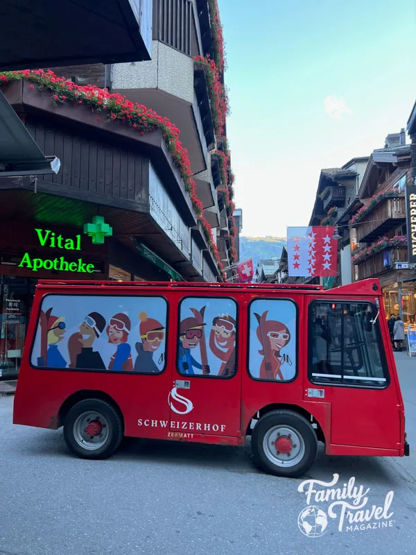 Red electric vehicle in front of shops