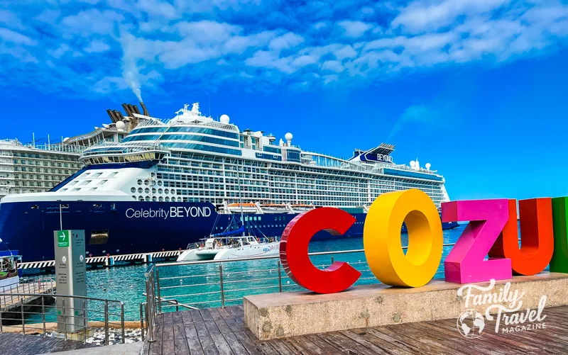 The Celebrity Beyond docked at Cozumel with large colorful letters in the foreground. 