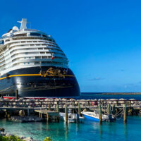 Disney Dream cruise ship docked at Castaway Cay with pier and small boats