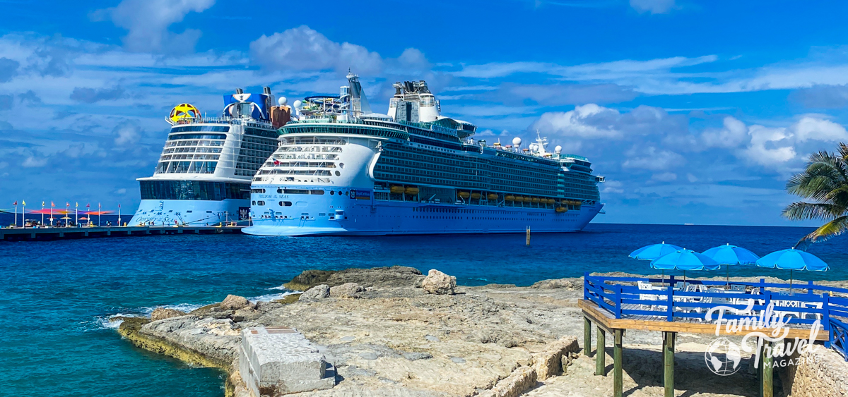 Two Royal Caribbean ships docked at Castaway cay with a rock slab in the foreground. 