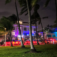 the exterior of the Marriott vacation club pulse with red lights, and palm trees in the foreground