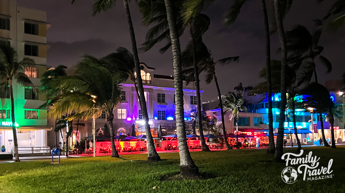the exterior of the Marriott vacation club pulse with red lights, and palm trees in the foreground 