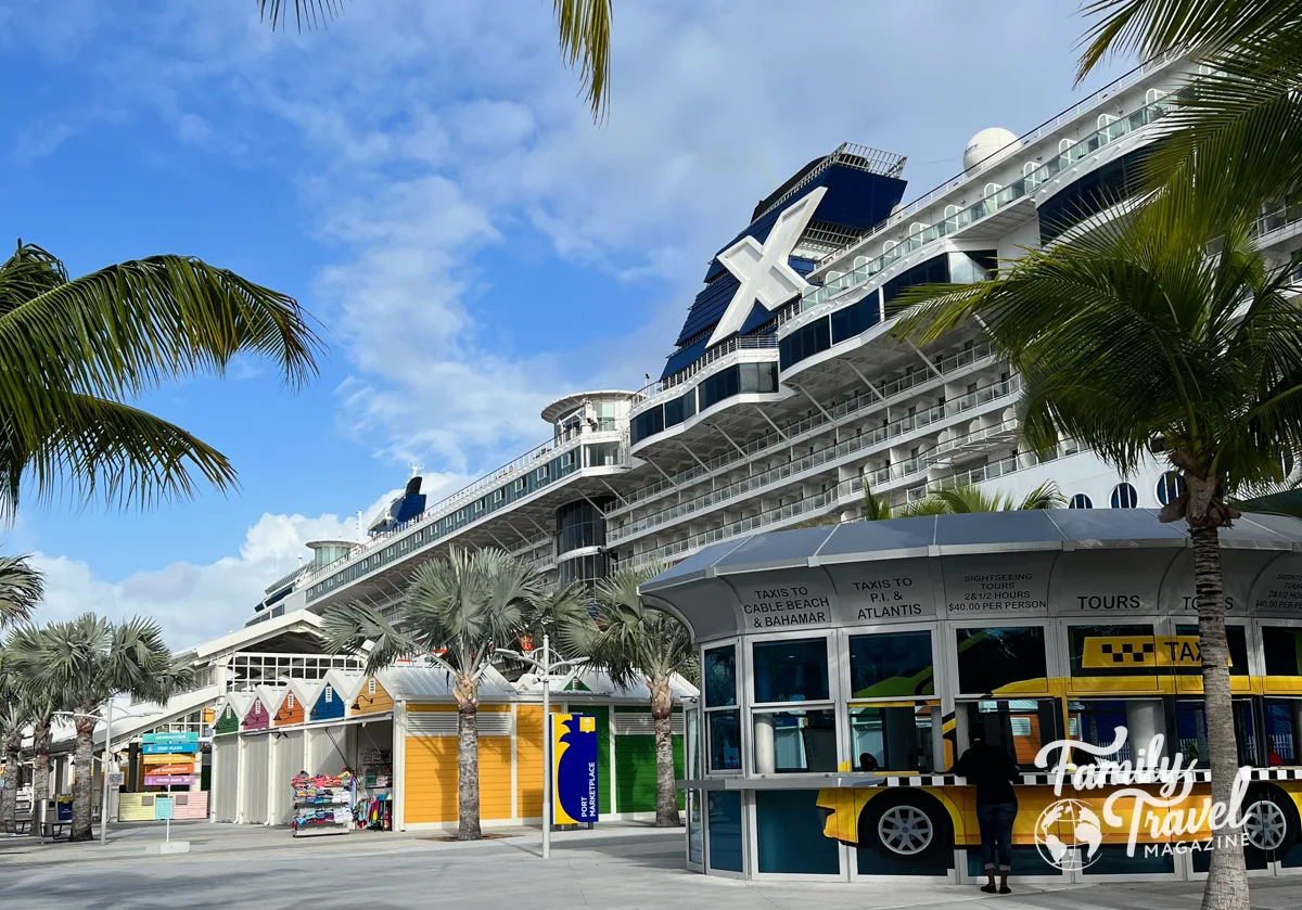 The Celebrity Summit docked at Nassau with palm trees and shops/kiosks. 