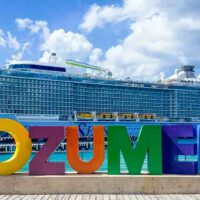 Odyssey of the Seas ship docked in front of colorful Cozumel letters.