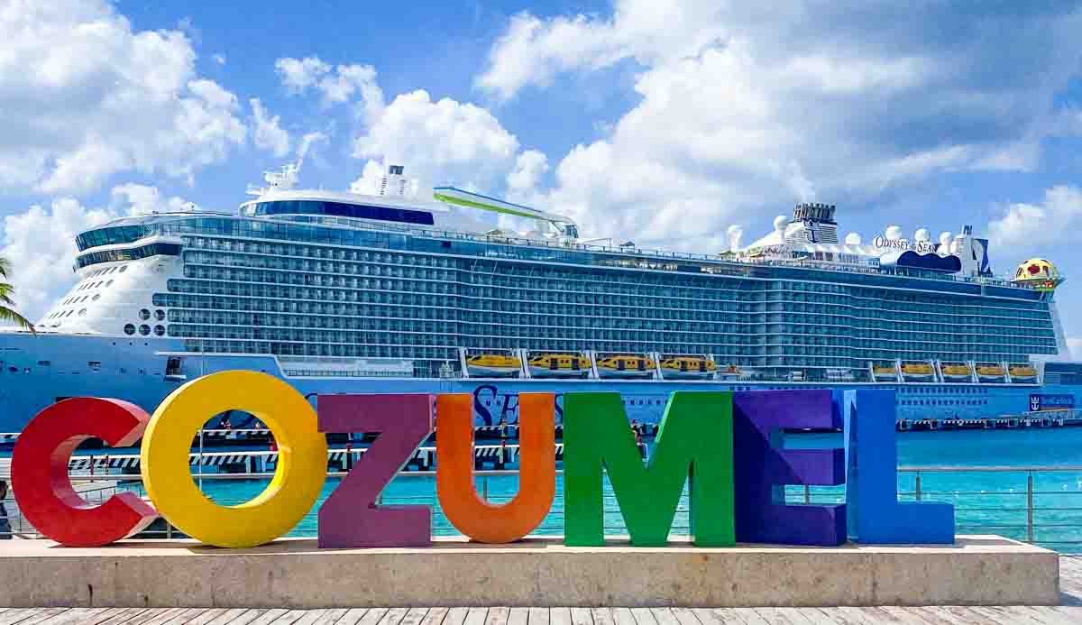 Odyssey of the Seas ship docked in front of colorful Cozumel letters. 