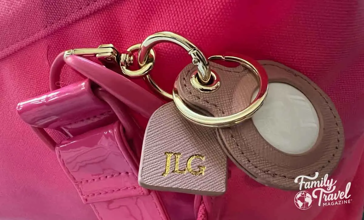 Light pink monogrammed AirTag holder on a pink bag