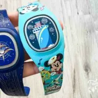 two cruise-themed blue DisneyBands in a hand.