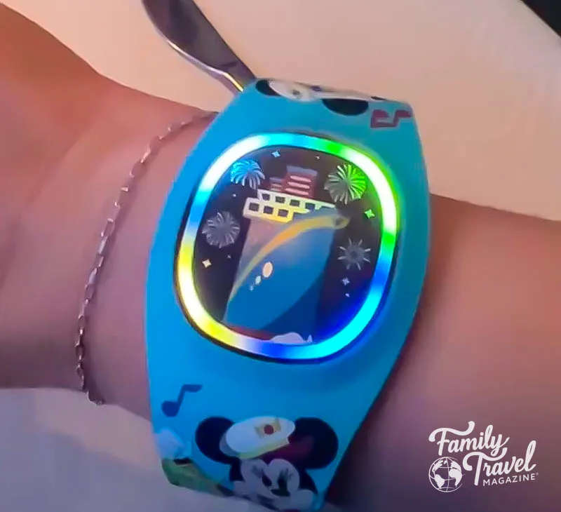 DisneyBand on wrist lit up in multi-colors