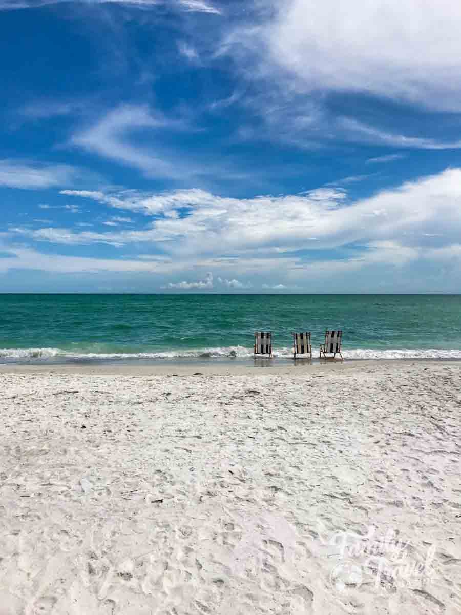 Three stripes beach chairs along the water front on a beach
