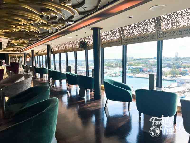 Chairs along windows overlooking the port in a bar