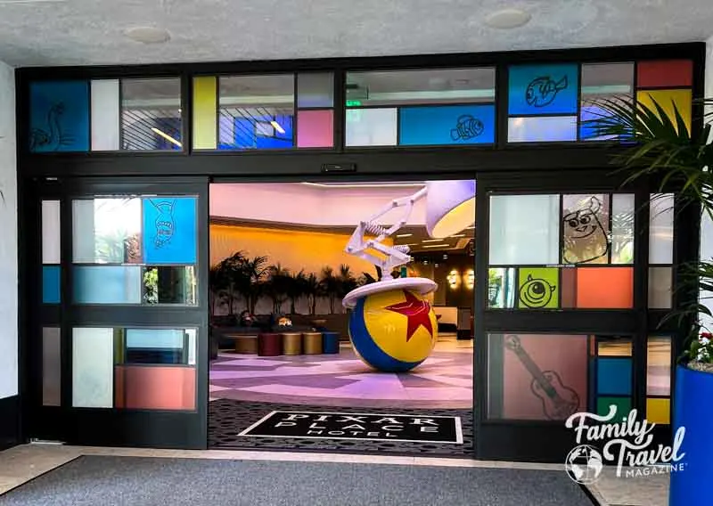 Colorful entrance to Pixar Place Hotel with pixar ball and lamp in lobby