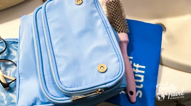 toiletry bags, brush, and glasses on sink