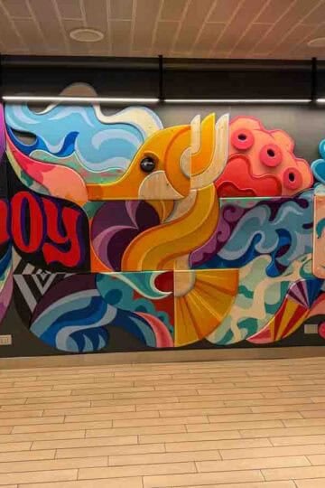 Colorful cruise ship mural with abstract sea life, tentacles, and the words “Ahoy” and “Brilliant” on Virgin Voyages’ Brilliant Lady