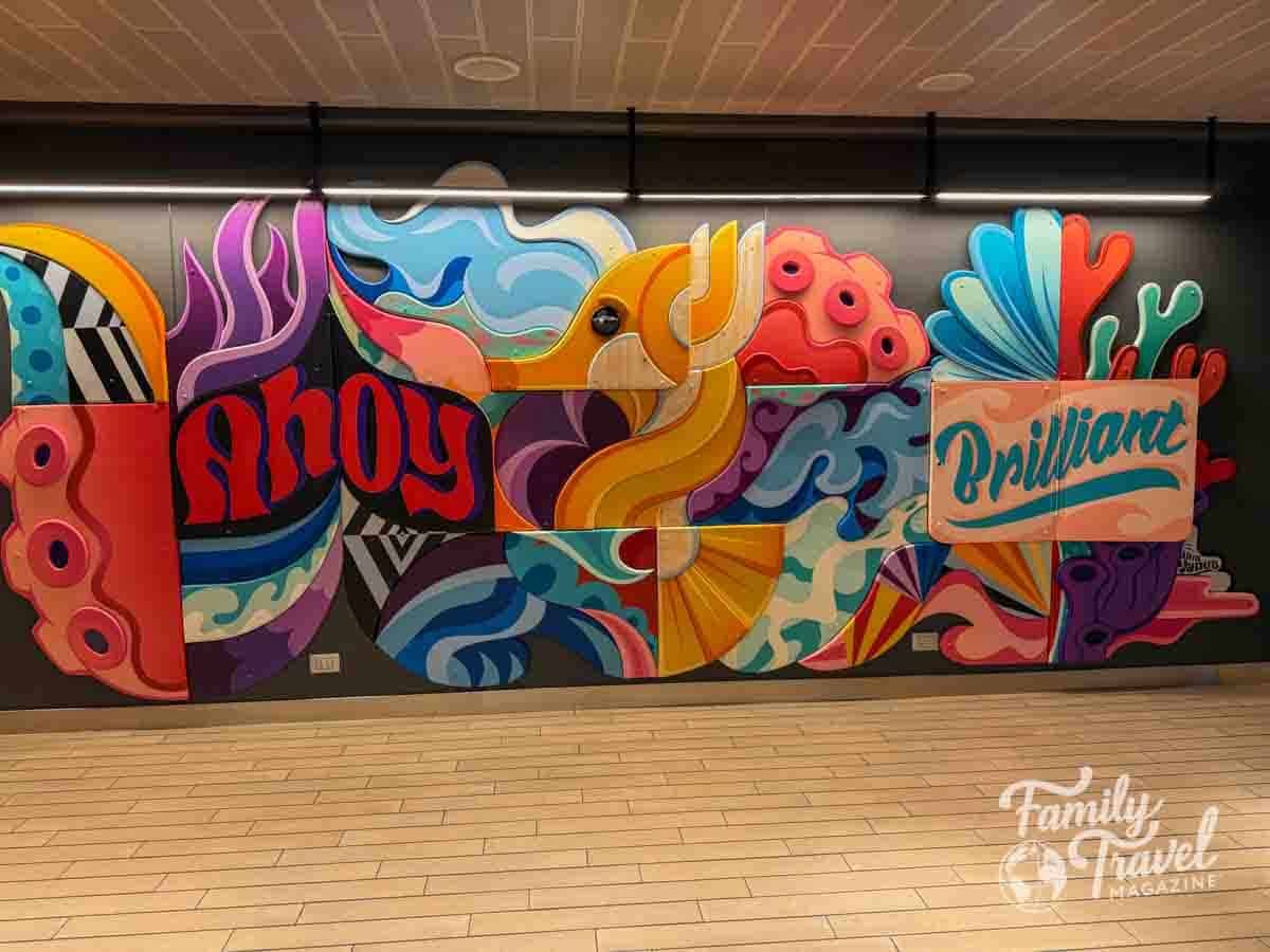 Colorful cruise ship mural with abstract sea life, tentacles, and the words “Ahoy” and “Brilliant” on Virgin Voyages’ Brilliant Lady
