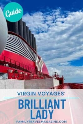 Virgin Voyages Brilliant Lady cruise ship deck with bold red design and smokestacks against a partly cloudy blue sky – guide to sailing with Virgin Voyages’ newest ship from Family Travel Magazine.