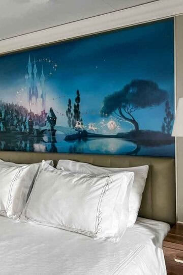 Disney Cruise Line stateroom with queen bed and fairytale castle mural headboard