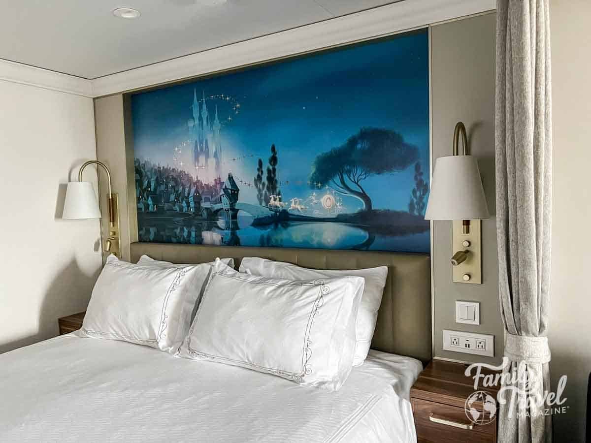 Disney Cruise Line stateroom with queen bed and fairytale castle mural headboard