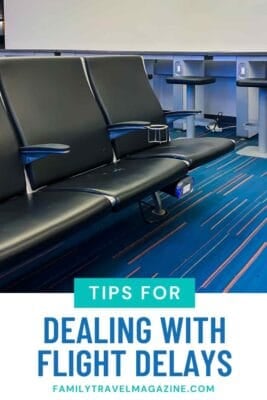 Empty airport waiting area with modern black leather seats, blue patterned carpet, and power outlets beneath the chairs, with a text overlay reading ‘Tips for Dealing with Flight Delays – FamilyTravelMagazine.com.