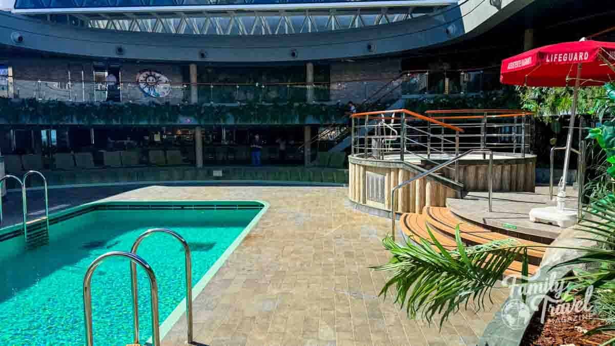 Indoor swimming pool area with lifeguard umbrella and upper level bar.
