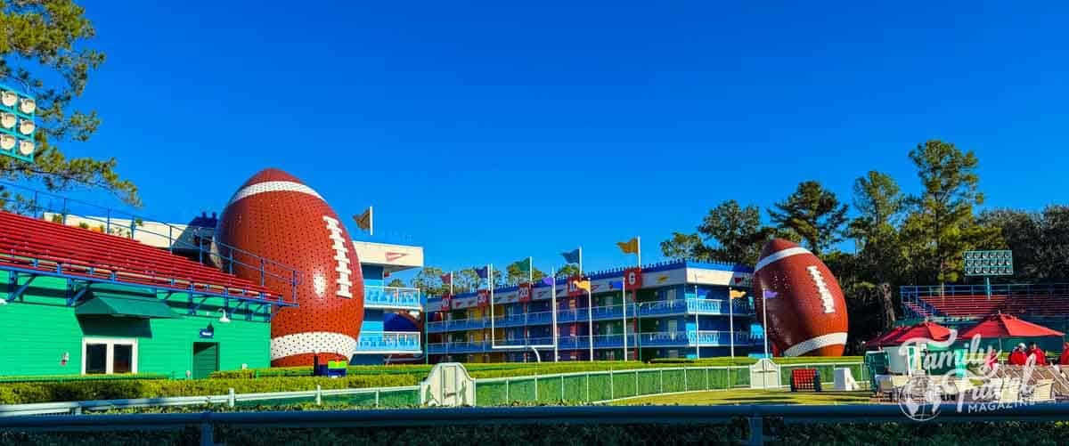 Colorful buildings and giant footballs decorate a sunny sports-themed resort.