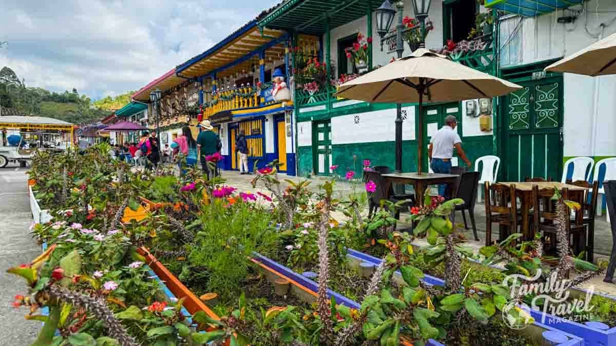 Vibrant colonial buildings and outdoor cafes with people in Salento, Colombia.