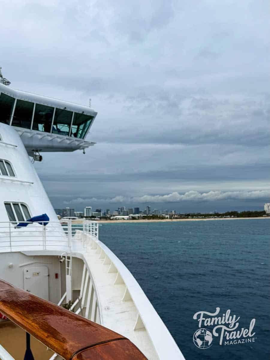 Cruise ships bow overlooking the Fort Lauderdale skyline and beach under a cloudy sky.