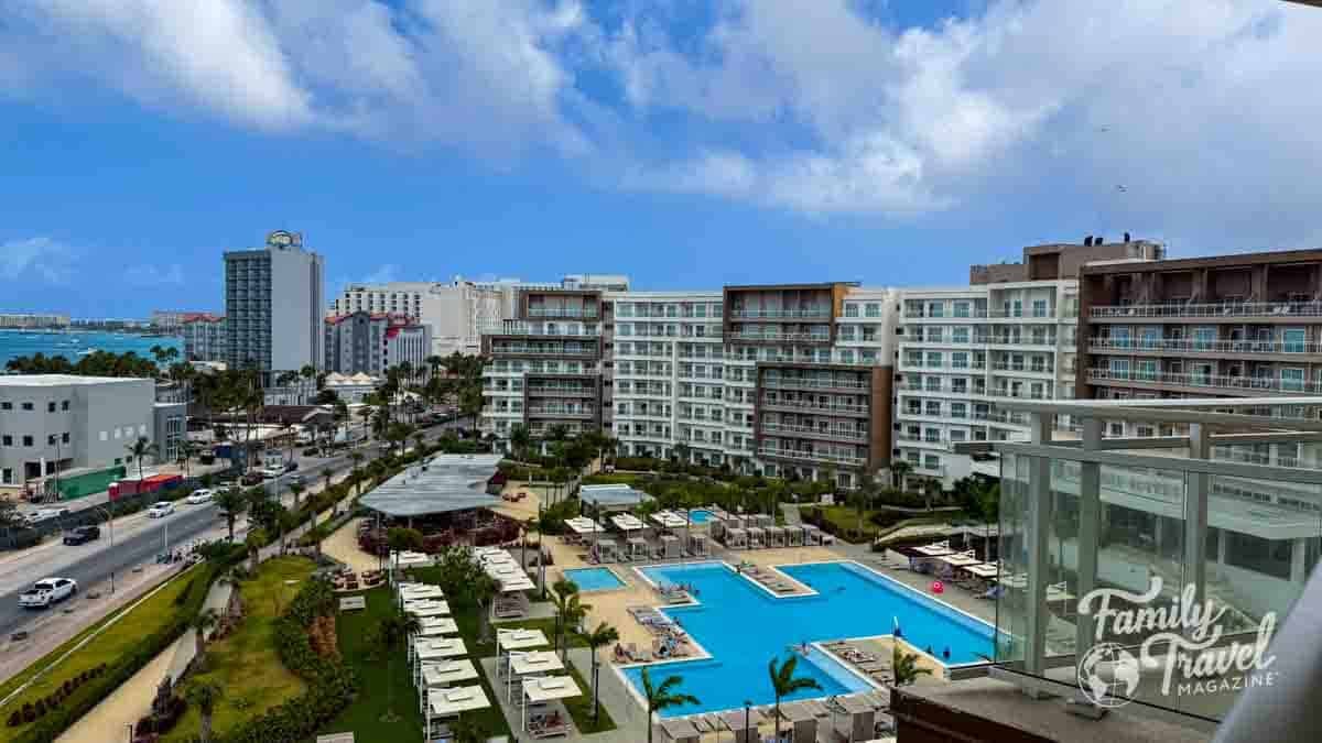 Elevated view of the Embassy Suites by Hilton Aruba Resort pool and buildings, with the ocean nearby.