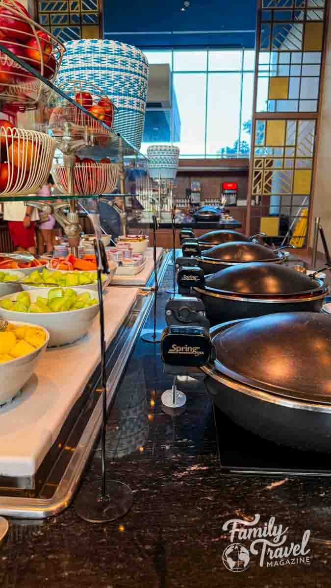 Vibrant breakfast buffet with fresh fruit and hot food warmers at a resort in Aruba.