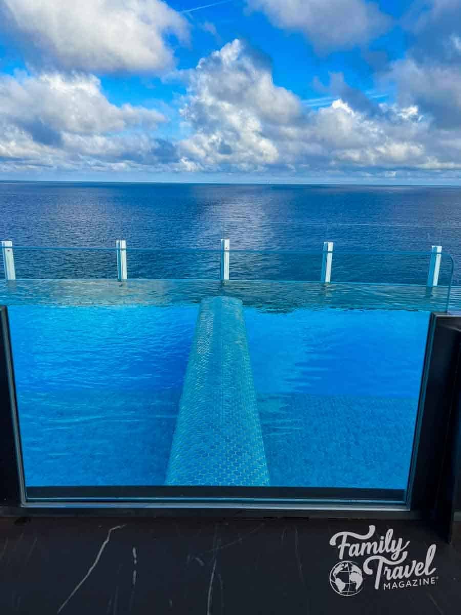 Infinity-style pool in the adults-only Quiet Cove area aboard the Disney Wish, overlooking the open ocean through floor-to-ceiling windows.