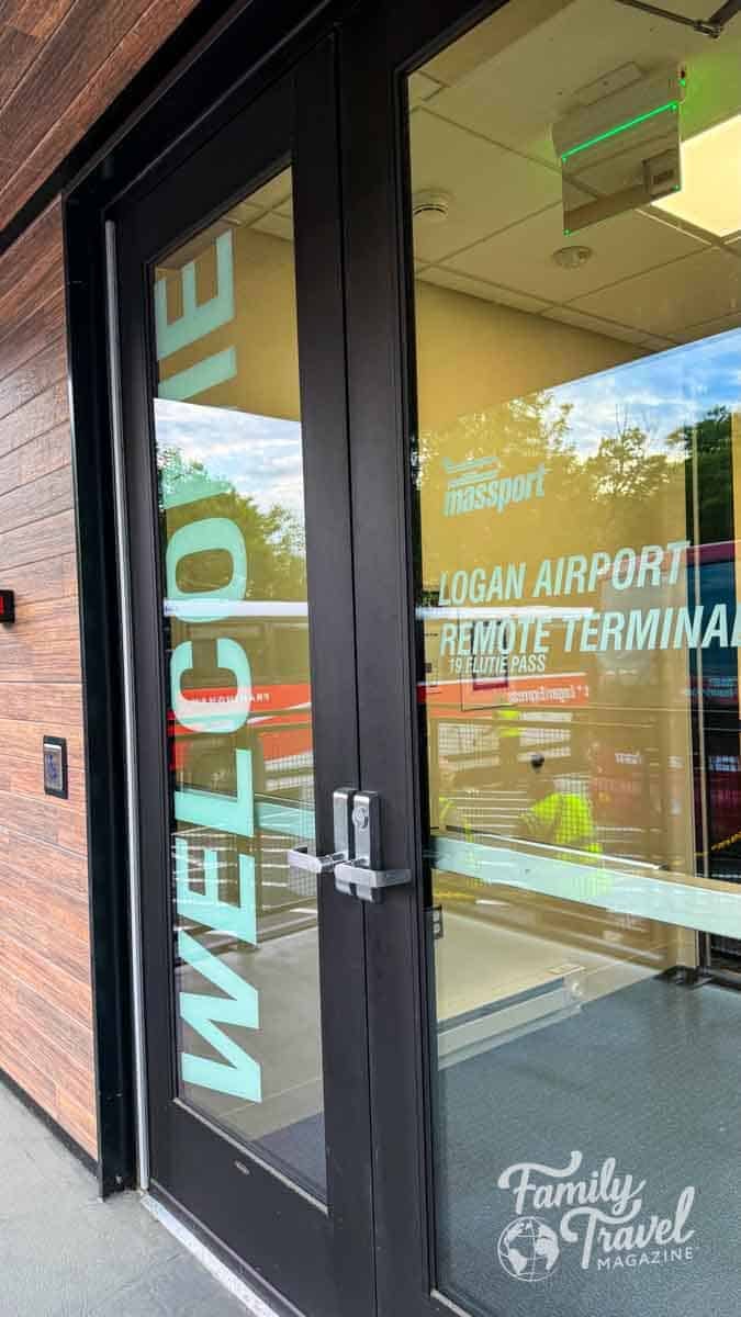 Entrance to Logan Airport Remote Terminal with WELCOME text on the glass door.