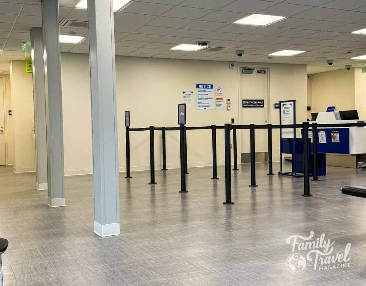 An empty queue line with stanchions leading to a Delta Airlines check-in counter in an airport.