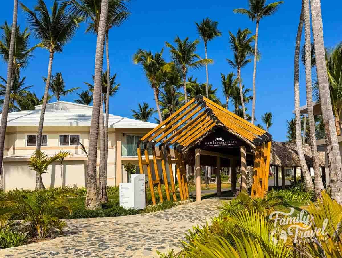 Entrance to Family Selection at Grand Palladium Punta Cana Resort & Spa, surrounded by palm trees.
